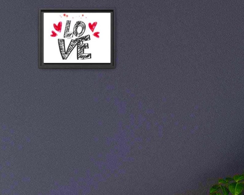 以下が含まれることがあります： 黒の手書き文字で「LOVE」と書かれた額入りのプリント。赤いハートと飛沫が単語の上を飾っています。フレームは黒で、背景は白です。