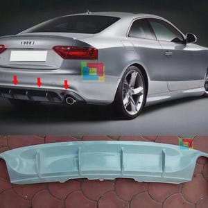 Könnte beinhalten: Silbernes Coupé mit Heckstoßstange und separatem hellblauem Heckdiffusor. Das Auto hat ein schlankes Design mit Leichtmetallfelgen. Der Diffusor hat eine einzigartige Form mit mehreren Abschnitten.