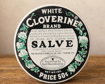 May include: A round metal tin of White Cloverine Brand Salve with a black and white label featuring green clover illustrations. The text includes ingredients, manufacturer details, a Good Housekeeping guarantee seal, and a net weight of 1 ounce.