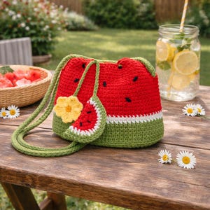 Può includere: Una borsa all'uncinetto rossa e verde a tema anguria con un portamonete abbinato e un accento floreale giallo. La borsa ha un cinturino verde e finiture bianche. Il testo "Crochet Pattern" è in basso nell'immagine.