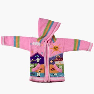 Puede incluir: Suéter con capucha rosa con cierre de cremallera y motivos de paisaje bordados. La capucha tiene rayas arcoíris. El diseño incluye un sol, nubes, animales y una casa, creando un aspecto caprichoso y acogedor.