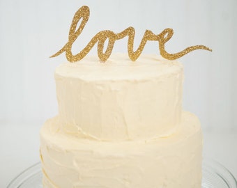 Gold glitter "LOVE" script wedding cake topper