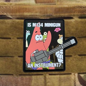 Puede incluir: Un parche negro con una imagen de dibujos animados de Patricio Estrella de Bob Esponja sosteniendo una minigun. El texto en el parche dice "IS M134 MINIGUN AN INSTRUMENT?" El parche tiene un respaldo de velcro.