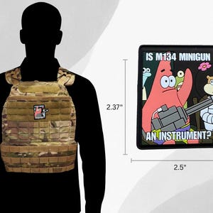 Puede incluir: Un chaleco t&aacute;ctico de camuflaje con un parche y un parche rectangular de 6,35 cm de ancho y 6,02 cm de alto. El parche presenta un personaje de dibujos animados sosteniendo una minigun con el texto "IS M134 MINIGUN AN INSTRUMENT?"