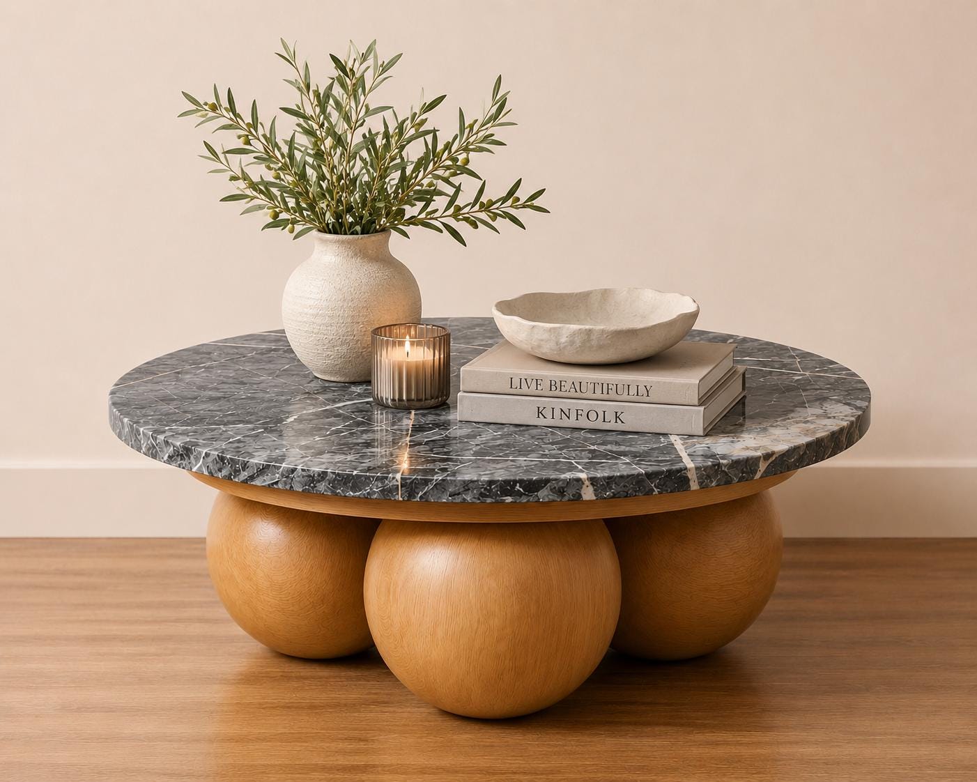 A round Grigio Carnico marble coffee table on timber sphere bases.