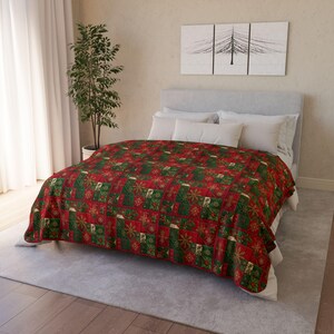 Può includere: Una trapunta natalizia rossa e verde su un letto. La trapunta presenta un design patchwork con quadrati di motivi rossi, verdi e dorati, tra cui fiocchi di neve, alberi di Natale e agrifoglio. Il letto ha cuscini bianchi e una testiera grigio chiaro.