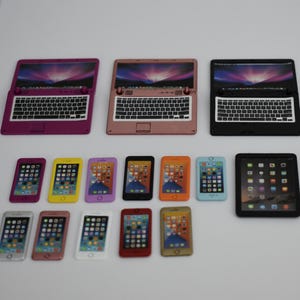 Könnte beinhalten: Eine Sammlung von Miniatur-Spielzeug-Laptops und Smartphones in verschiedenen Farben. Die Laptops sind geöffnet und zeigen ein Bildschirmbild, die Smartphones sind darunter angeordnet. Farben: Pink, Schwarz, Gelb und Orange.