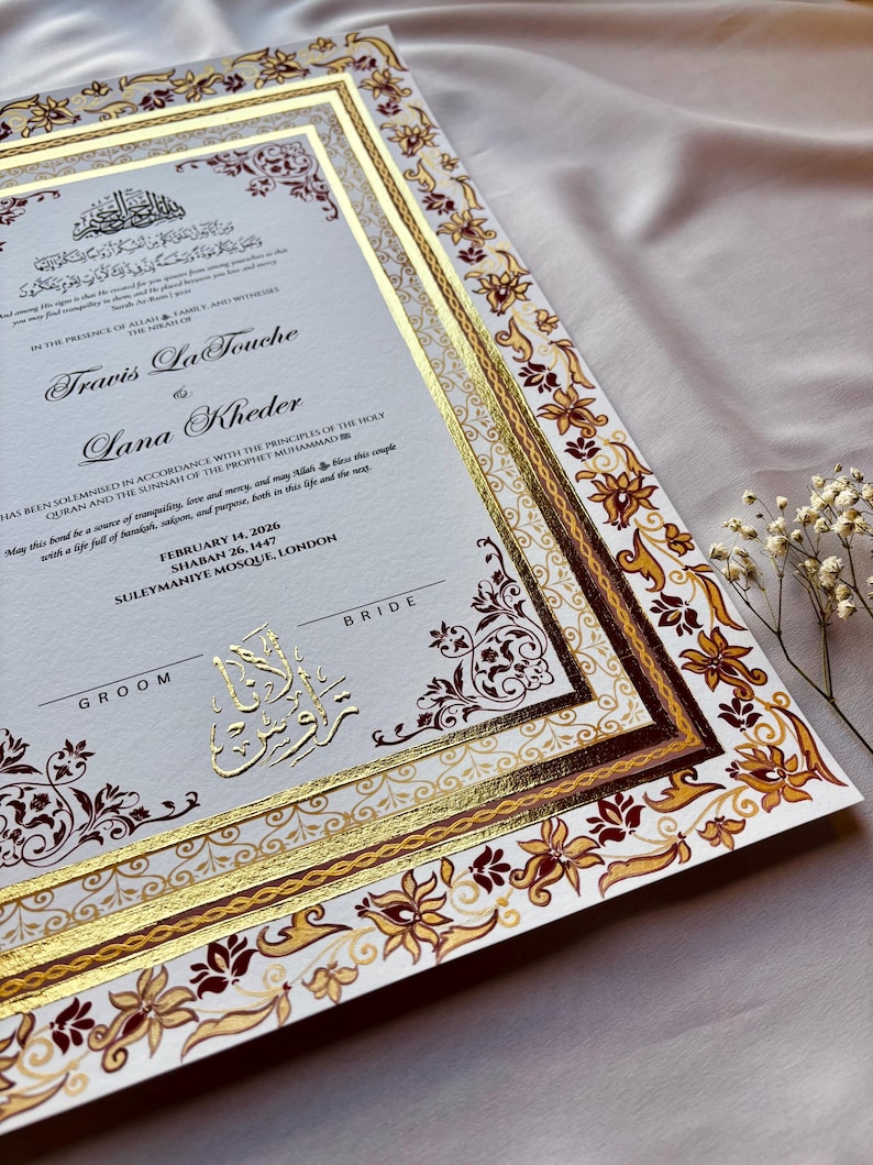 Może przedstawiać: Zaproszenie ślubne ze złotymi akcentami i ozdobnymi wzorami kwiatowymi i geometrycznymi. Zaproszenie zawiera nazwiska "Travis La Touche" i "Lana Kheder" w eleganckiej czcionce, a także arabską kaligrafię i szczeg&oacute;ły wydarzenia.