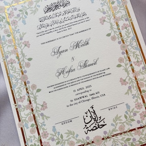 May include: A wedding certificate with floral border and gold accents. The document features the names Ayan Malik and Hafsa Ahmed, along with Arabic script and English text. The date of the marriage is April 15, 2025, in Chicago, Illinois.