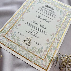 May include: A wedding certificate with floral and gold accents. The document features the names Ayan Malik and Hafsa Ahmed, along with the date April 15, 2025, and the city of Chicago, Illinois, USA. The text is in English and Arabic.