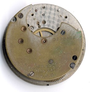 May include: Close-up of the back of a watch movement with the text "NEW YORK STANDARD WATCH CO. U.S.A." and the number "3682630".