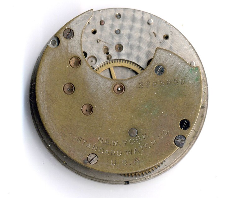 May include: Close-up of the back of a watch movement with the text "NEW YORK STANDARD WATCH CO. U.S.A." and the number "3682630".