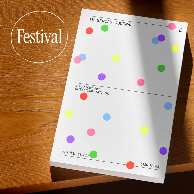 Op de afbeelding: Een wit notitieboek met kleurrijke stippen, de tekst "TV SERIES JOURNAL" en "A NOTEBOOK FOR INTENTIONAL WATCHING". De cover bevat ook de tekst "BY K&Uuml;&Ntilde;EL STUDIO" en "(120 PAGES)". Het woord "Festival" staat in een cirkel linksboven.