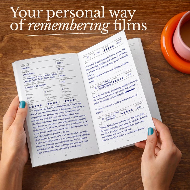 Op de afbeelding: Een open notitieboek met filmrecensies, met de tekst "Your personal way of remembering films". De linkerpagina bevat een recensie van "Euphoria" met handgeschreven notities. De rechterpagina bevat meer recensies. Een kopje koffie staat op de achtergrond.