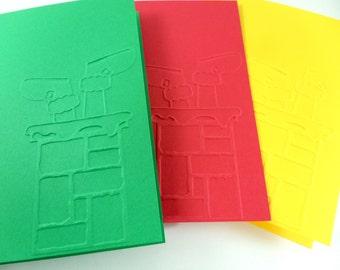 May include: Three colorful Christmas cards in green, red, and yellow. Each card features an embossed design of Santa's legs and chimney. The cards are rectangular and have a textured surface, perfect for holiday greetings.