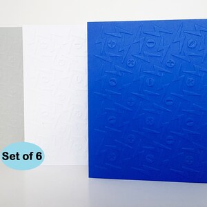 May include: Set of six blank greeting cards with a textured embossed pattern of lightning bolts and plus and minus signs. The cards are in three colors: gray, white, and blue.