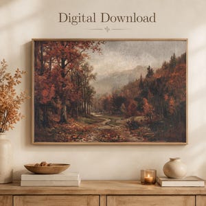 May include: A rectangular wall art print featuring a landscape painting of an autumn forest with red and brown foliage, a winding path, and distant mountains. The text Digital Download is centered above the framed artwork in a serif font.