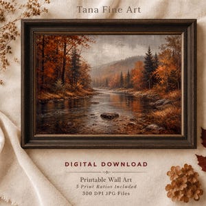 Puede incluir: Una impresión de paisaje enmarcada titulada Tana Fine Art que muestra un río que fluye a través de un bosque otoñal con follaje naranja y marrón, árboles de hoja perenne oscuros y orillas rocosas. El texto indica DIGITAL DOWNLOAD, Printable Wall Art.