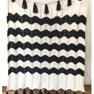 May include: Black and white chevron crochet blanket with black tassels. Easy Crochet Pattern by Deborah O'Leary Patterns.