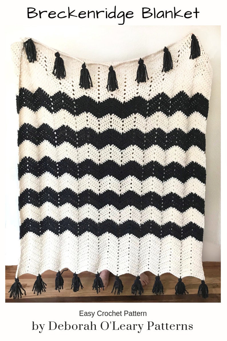 May include: Black and white chevron crochet blanket with black tassels. Easy Crochet Pattern by Deborah O'Leary Patterns.