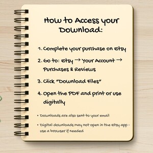 May include: A spiral-bound notebook with instructions on how to access a digital download from Etsy. The text is in black ink on a cream-colored page. Green paper clips are in the lower left corner. The notebook is on a light wood surface.