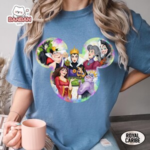 A person wearing a blue t-shirt with a colorful illustration of Disney characters from the animated film series.