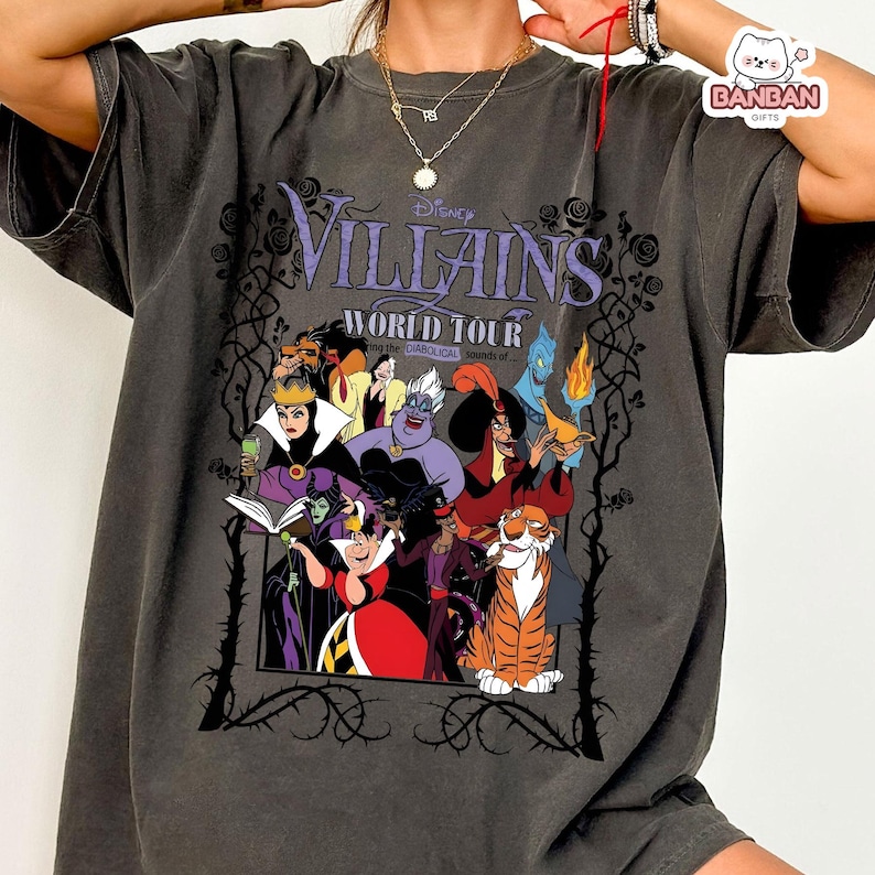 A person wearing a gray t-shirt with a graphic design featuring characters from the Disney film " Villains World Tour".