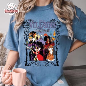 A person wearing a blue t-shirt with a graphic design featuring characters from the Disney film " Villains: World Tour".