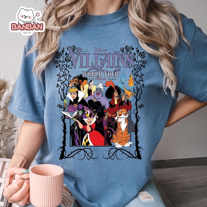 A person wearing a blue t-shirt with a graphic design featuring characters from the Disney film " Villains: World Tour".