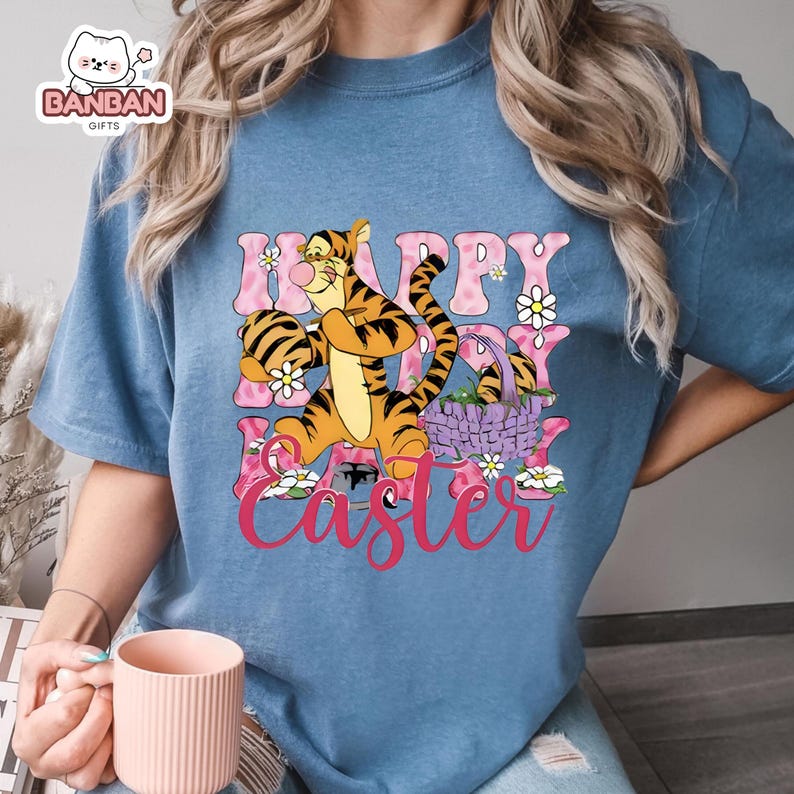 A person wearing a blue t-shirt with a cartoon image of Tigger, a character from Winnie the Pooh, and the text "Happy Easter" printed on it.