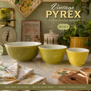 Puede incluir: Un juego de tres cuencos mezcladores apilables Pyrex Verde en tonos degradados de oliva y amarillo. Los cuencos presentan un acabado exterior liso y brillante con un interior blanco sólido. Estos cuencos de cocina redondos y profundos están alineados.