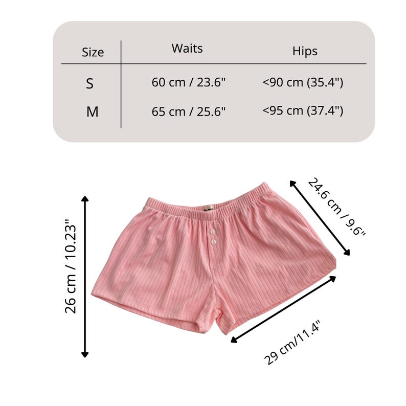 May include: Light pink ribbed shorts with an elastic waistband and two front buttons. A size chart displays waist measurements of 23.6 inches for size S and 25.6 inches for size M, with hip measurements of 35.4 inches and 37.4 inches respectively.