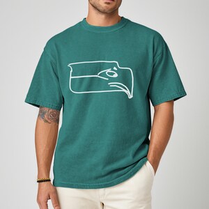 Seattle football team meme shirt designed as a Sam Darnold hand drawn logo shirt with humorous illustrated details, funny Seattle sports t shirt perfect for championship winner celebrations, ideal gift for football fan shirt, unisex football apparel great for game days, tailgating events, watch parties, casual wear, sports bar outfits, Seattle themed fan clothing, and meme lovers who enjoy playful sports fashion