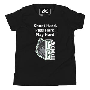 Puede incluir: Camiseta negra juvenil con el texto "Shoot Hard. Pass Hard. Play Hard." sobre una cabeza de lobo y el logo "GC HOCKEY". La camiseta es de material suave, adecuada para los entusiastas del deporte.