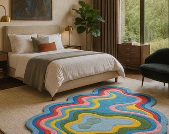 May include: A colorful, abstract rug with a wavy design in a bedroom setting. The rug features layers of blue, pink, red, yellow, and green. The room includes a bed, artwork, and a large window overlooking a green landscape.