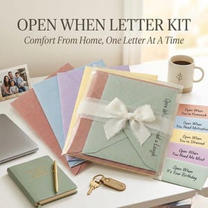 May include: An Open When Letter Kit featuring a stack of pastel-colored envelopes tied with a white ribbon, a green notebook with a gold pen, a key, and five labeled cards reading Open When You're Homesick, Need Motivation, Stressed, Need Me Most, or Birthday.