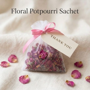 May include: A floral potpourri sachet in a sheer white bag tied with a pink ribbon and a "THANK YOU" tag. The bag is filled with dried rose petals and herbs. Scattered around are loose pink rose petals. The text "Floral Potpourri Sachet" is at the top.