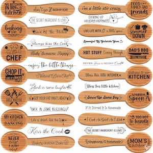 May include: Wooden spoons with engraved text, including phrases like "No bitchin' in my kitchen," "Baking is my therapy," and "I'm a little stir crazy." The spoons are light brown and feature various kitchen-themed quotes.