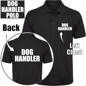 Puede incluir: Un polo negro de manga corta con el texto blanco DOG HANDLER impreso en el pecho izquierdo y una versión más grande del mismo texto en la espalda. La prenda cuenta con un cuello clásico y una tapeta frontal con tres botones.