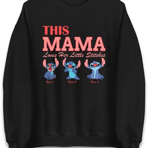 May include: Black sweatshirt with the text "THIS MAMA Loves Her Little Stitches" in red. Below the text are three blue cartoon characters. The sweatshirt is a crew neck style.