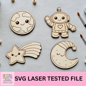 May include: Four wooden cutouts with space-themed designs: a smiling planet, an astronaut, a shooting star, and a crescent moon. The cutouts are made of light-colored wood and feature cute, cartoonish faces. The text "SVG LASER TESTED FILE" is visible.
