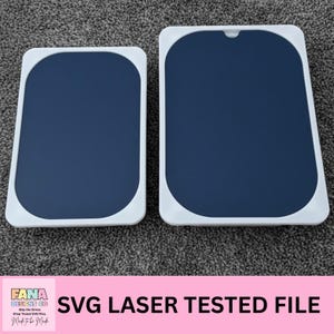 Puede incluir: Dos objetos rectangulares azul marino con esquinas redondeadas y marcos blancos. El texto "SVG LASER TESTED FILE" se muestra en negro sobre una pancarta rosa. El logotipo "FANA DESIGNS CO" también es visible.