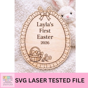 May include: Wooden Easter egg-shaped sign with the text "Layla's First Easter 2026". The sign features a bow, a basket with eggs, and floral accents. The sign is laser-cut and has a decorative scalloped edge.