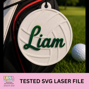 Può includere: Un'etichetta bianca per sacca da golf con il nome "Liam" in verde. Il design presenta un pallone da pallavolo. C'è un foro per appenderla. Una pallina da golf è sull'erba verde. Il testo "TESTED SVG LASER FILE" è in basso.