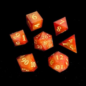 Puede incluir: Un juego de tres tazas de cerámica con un esmalte moteado de color crema. Cada taza presenta un diseño pintado a mano diferente: una hoja azul y verde, una flor amarilla y naranja y una ramita de bayas rojas.