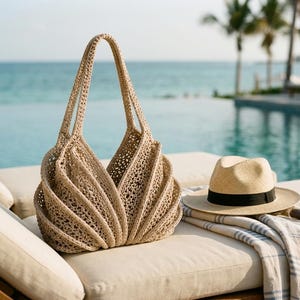 May include: A beige crochet tote bag with a structured, pleated design and two long handles, accompanied by a straw fedora hat with a black band and a white and blue striped fabric cloth, all featuring a textured, woven appearance.