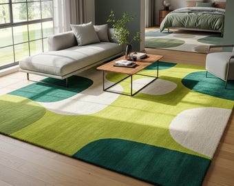 May include: A modern area rug with a geometric pattern of large, overlapping shapes in shades of green and white. The rug is placed in a living room setting with a gray sofa, wooden coffee table, and large windows. The rug's design adds a pop of color.