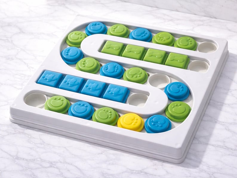 Pu&ograve; includere: Un giocattolo puzzle per cani in plastica bianca con una variet&agrave; di pezzi colorati rimovibili. I pezzi sono blu, verdi e gialli e includono forme come cerchi, quadrati e impronte di zampe. Il puzzle &egrave; progettato per stimolare la mente di un cane.