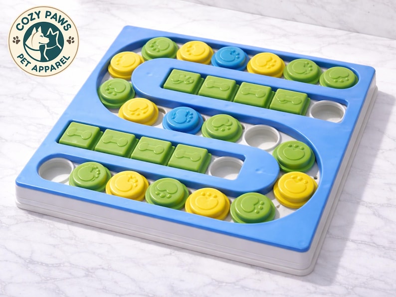 Pu&ograve; includere: Un giocattolo puzzle per cani blu e bianco con pezzi verdi, gialli e blu. Il giocattolo ha un design a labirinto con forme di ossa e impronte di zampe. Il logo Cozy Paws Pet Apparel si trova nell'angolo in alto a sinistra.