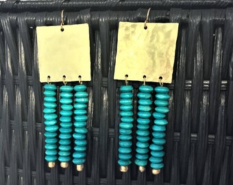 Peut inclure: Une paire de boucles d'oreilles dorées et turquoise avec un sommet carré et une frange de perles turquoise.